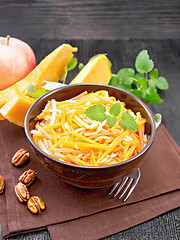 Image showing Salad of pumpkin and apple with nuts in bowl on black board