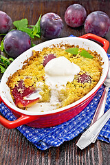 Image showing Crumble with plum and ice cream in brazier on wooden board