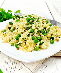 Image showing Couscous with spinach in plate on towel