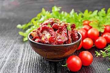 Image showing Tomatoes sun-dried in bowl on dark board