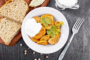 Image showing Mushrooms salted with sour cream in plate on board top