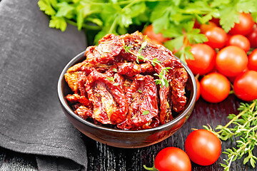 Image showing Tomatoes sun-dried in bowl with napkin on black board