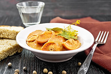 Image showing Mushrooms salted in plate with bread on wooden board