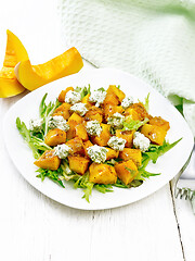 Image showing Salad of pumpkin and cheese in plate on wooden board