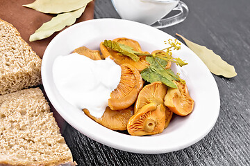 Image showing Mushrooms salted with sour cream in plate on black board