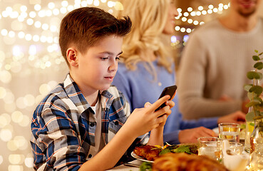 Image showing boy with smartphone at family dinner party