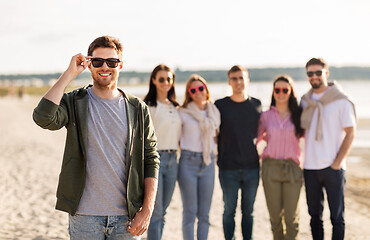 Image showing man in sunglasses with friends on beach in summer