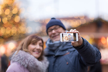 Image showing senior couple taking selfie at christmas market