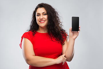 Image showing happy woman in red dress showing smartphone