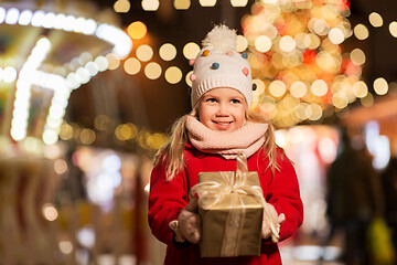 Image showing happy girl with gift box at christmas market