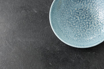 Image showing close up of blue ceramic plate on slate background