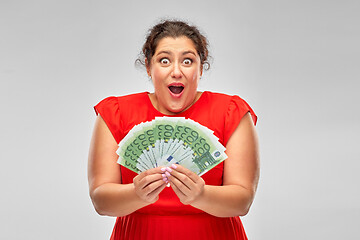 Image showing shocked woman holding hundreds of money banknotes