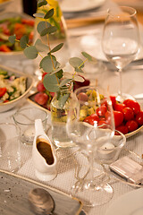 Image showing table served with plates, wine glasses and food