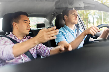 Image showing car driving school instructor teaching male driver