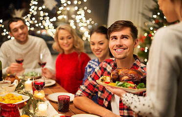 Image showing happy friends having christmas dinner at home