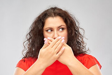 Image showing scared woman closing her mouth by hands