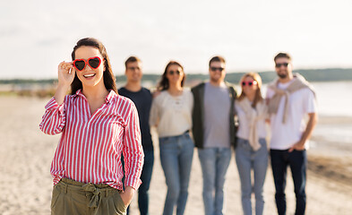 Image showing happy woman with friends on beach in summer