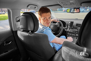 Image showing man or driver driving car and looking back