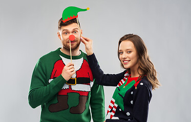 Image showing couple with christmas party props in ugly sweaters