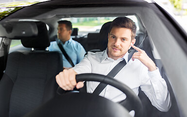 Image showing male driver with wireless earphones driving car