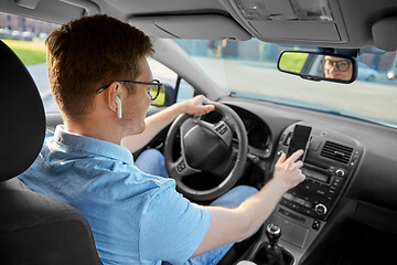 Image showing man driving car and using gps on smartphone