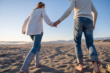 Image showing Loving young couple on a beach at autumn sunny day