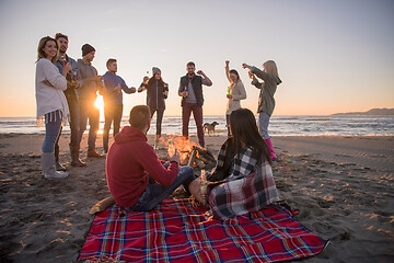 Image showing Couple enjoying with friends at sunset on the beach