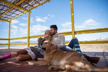 Image showing Couple with dog enjoying time on beach