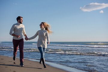 Image showing Loving young couple on a beach at autumn sunny day