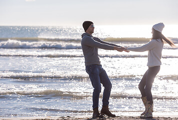 Image showing Loving young couple on a beach at autumn sunny day