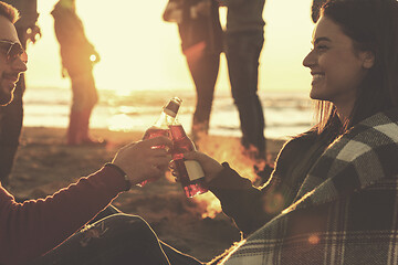 Image showing Couple enjoying with friends at sunset on the beach