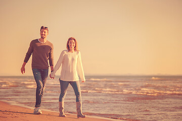 Image showing Loving young couple on a beach at autumn sunny day