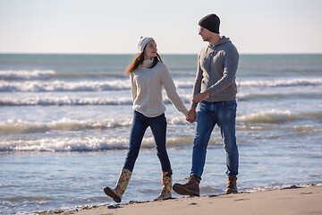 Image showing Loving young couple on a beach at autumn sunny day