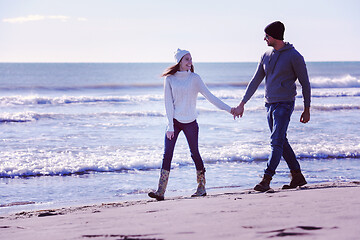 Image showing Loving young couple on a beach at autumn sunny day