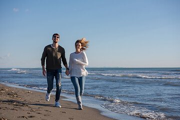 Image showing Loving young couple on a beach at autumn sunny day