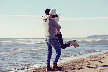 Image showing Loving young couple on a beach at autumn sunny day