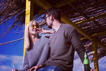 Image showing young couple drinking beer together at the beach