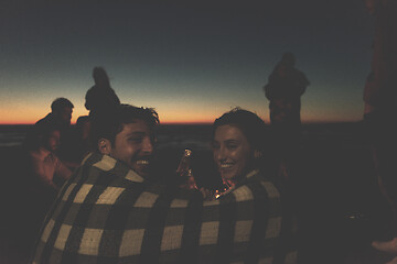 Image showing Couple enjoying with friends at sunset on the beach