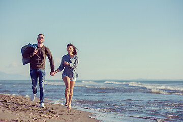 Image showing Loving young couple on a beach at autumn sunny day