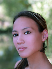 Image showing Young asian american woman outdoor portrait leaves