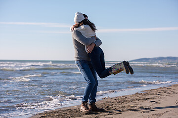 Image showing Loving young couple on a beach at autumn sunny day