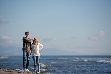 Image showing Loving young couple on a beach at autumn sunny day