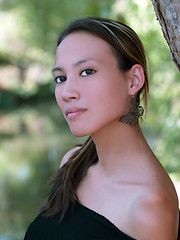 Image showing Portrait of young woman outdoors with green leaves