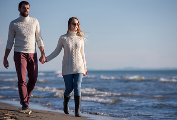 Image showing Loving young couple on a beach at autumn sunny day