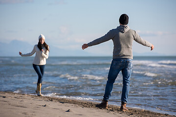 Image showing Loving young couple on a beach at autumn sunny day