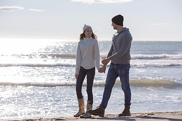 Image showing Loving young couple on a beach at autumn sunny day