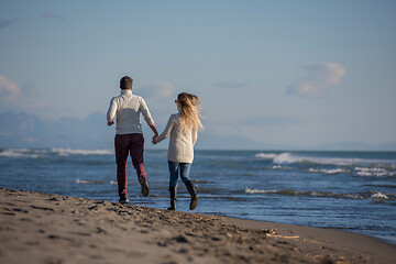 Image showing Loving young couple on a beach at autumn sunny day