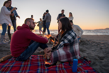 Image showing Couple enjoying with friends at sunset on the beach