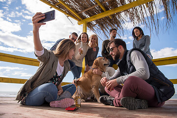 Image showing Group of friends having fun on autumn day at beach