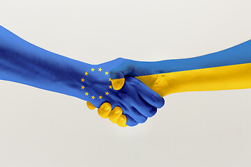 Image showing Two hands. Flag of the European Union. Flag of Ukraine.